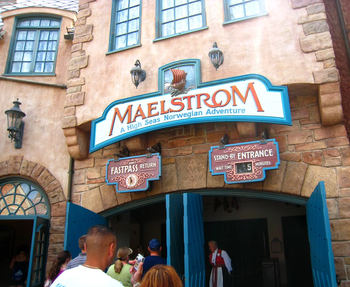 Maelstrom entrance sign above blue doors, with FastPass return and standby signs and visitors below.